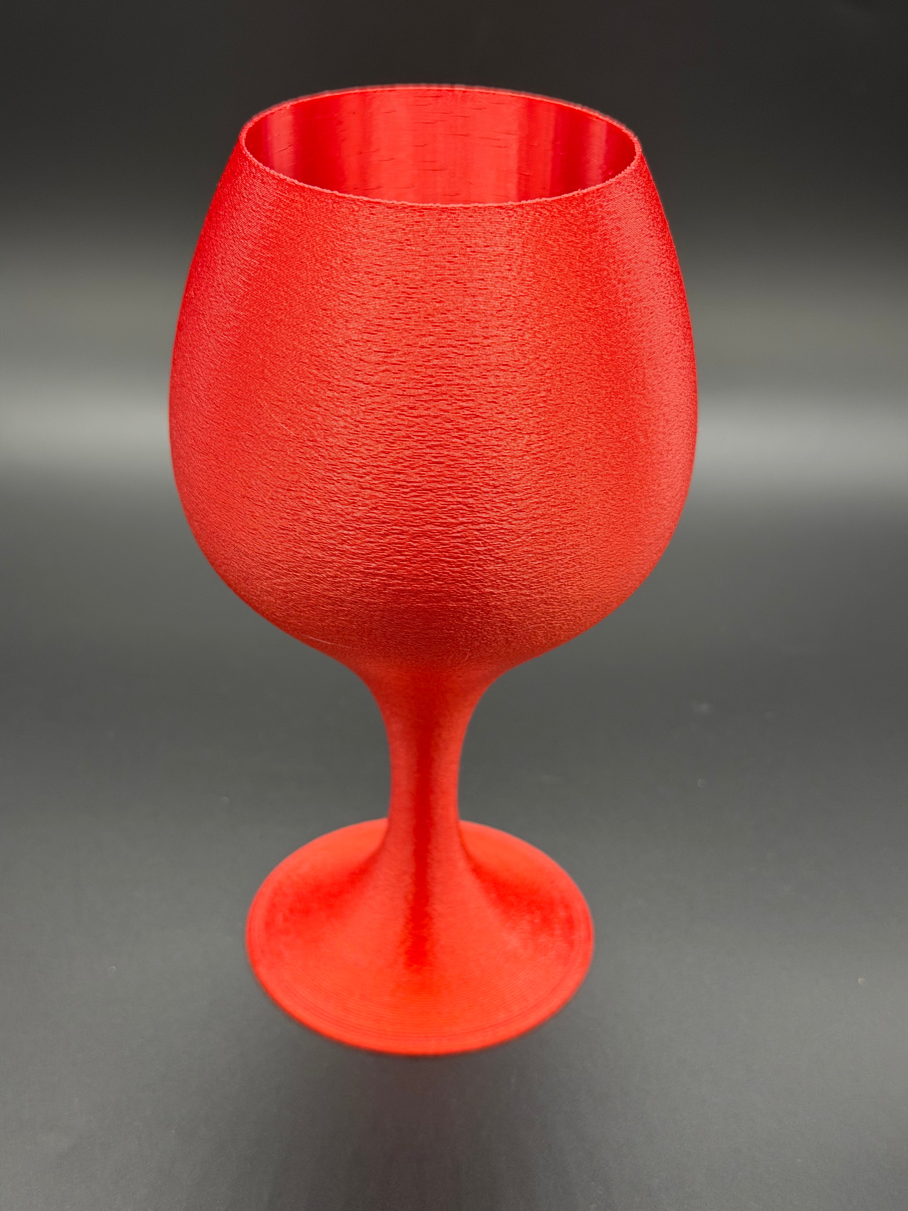 Red textured wine glass on a black background
