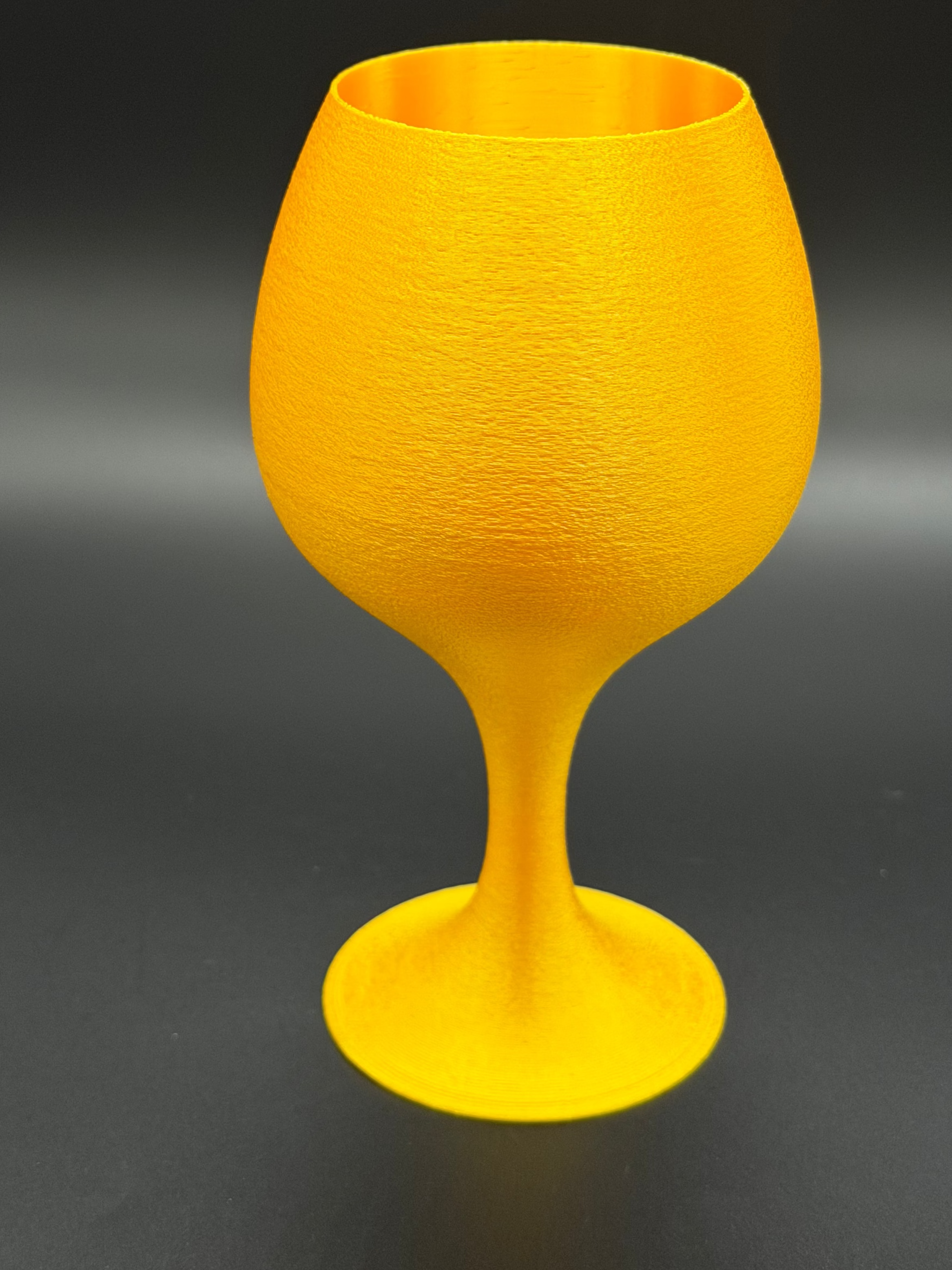Gold goblet-shaped object on a dark background