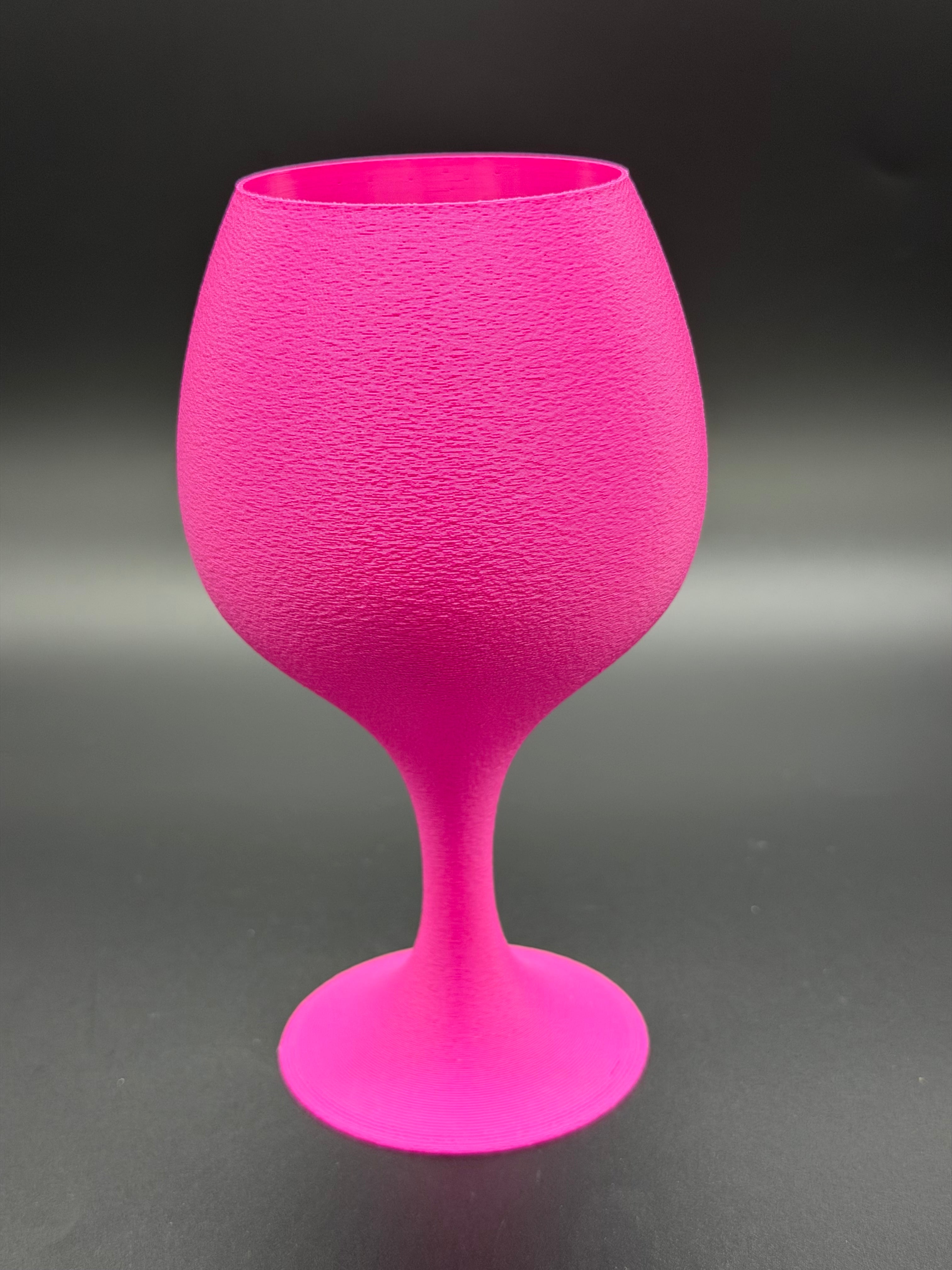 Magenta textured wine glass on a gray background